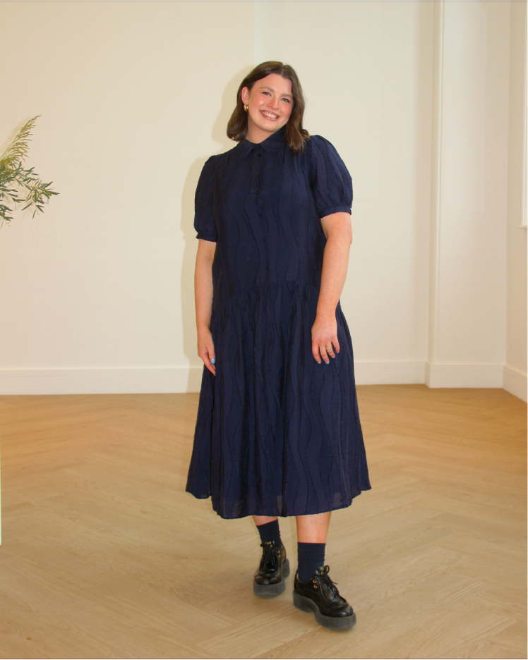 Woman standing for a picture in navy dress