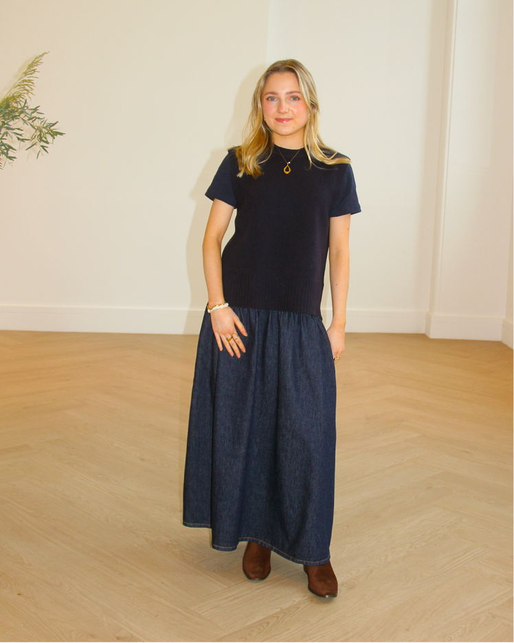 Woman standing for picture in denim skirt