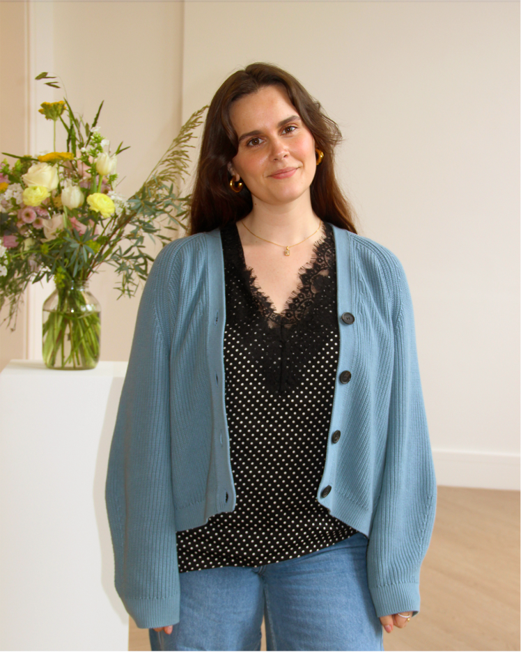 Portrait of woman posing for picture wearing blue cardigan and mini dots cami top